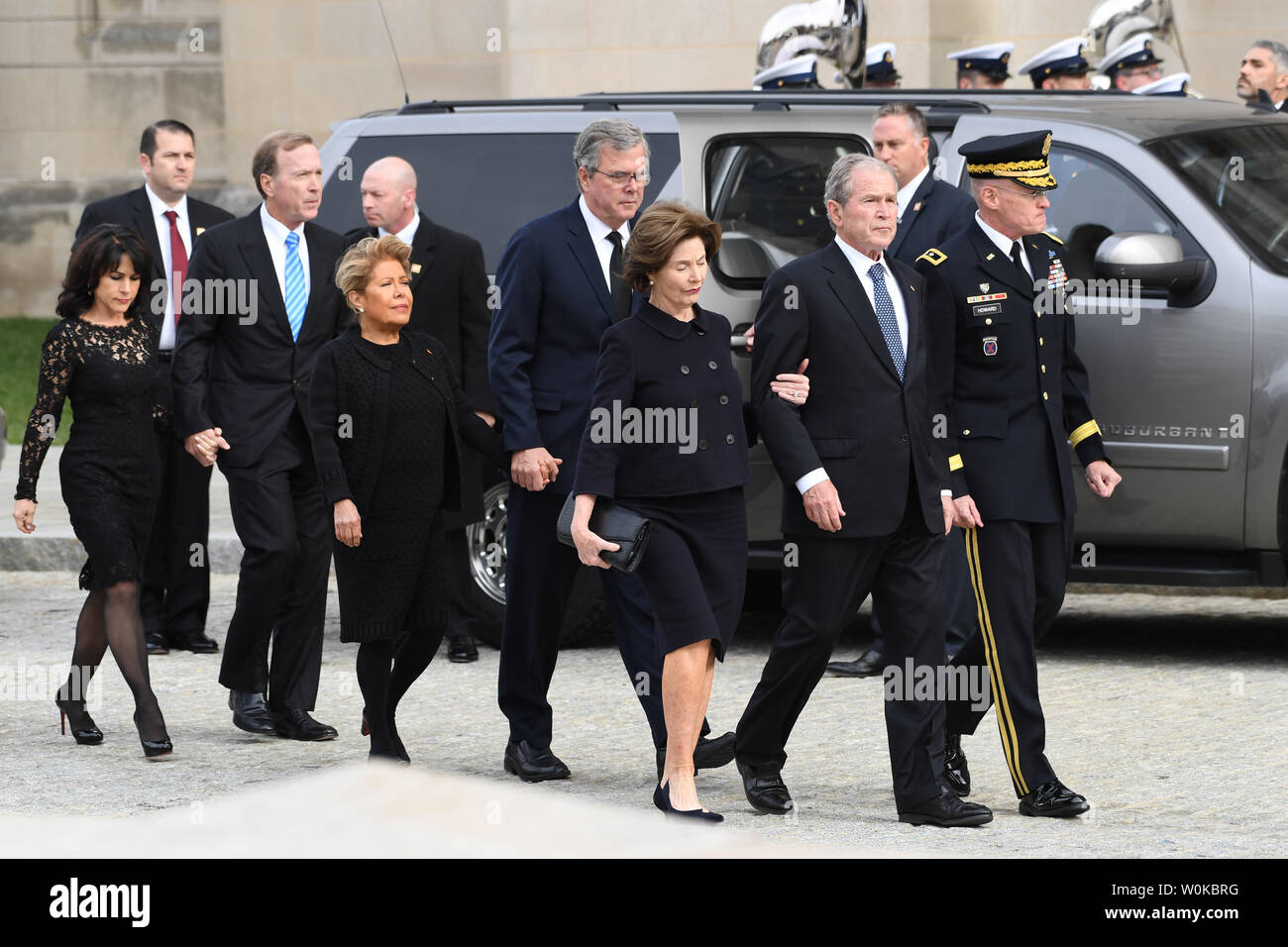 Former President Georrge W. Bush (R), Jeb Bush (C) and Neil Bush and their wives, watch the casket of President George H.W. Bush arrive at the National Catherdral for his funeral in Washington D.C. on December 5, 2018.  Photo by Pat Benic/UPI Stock Photo