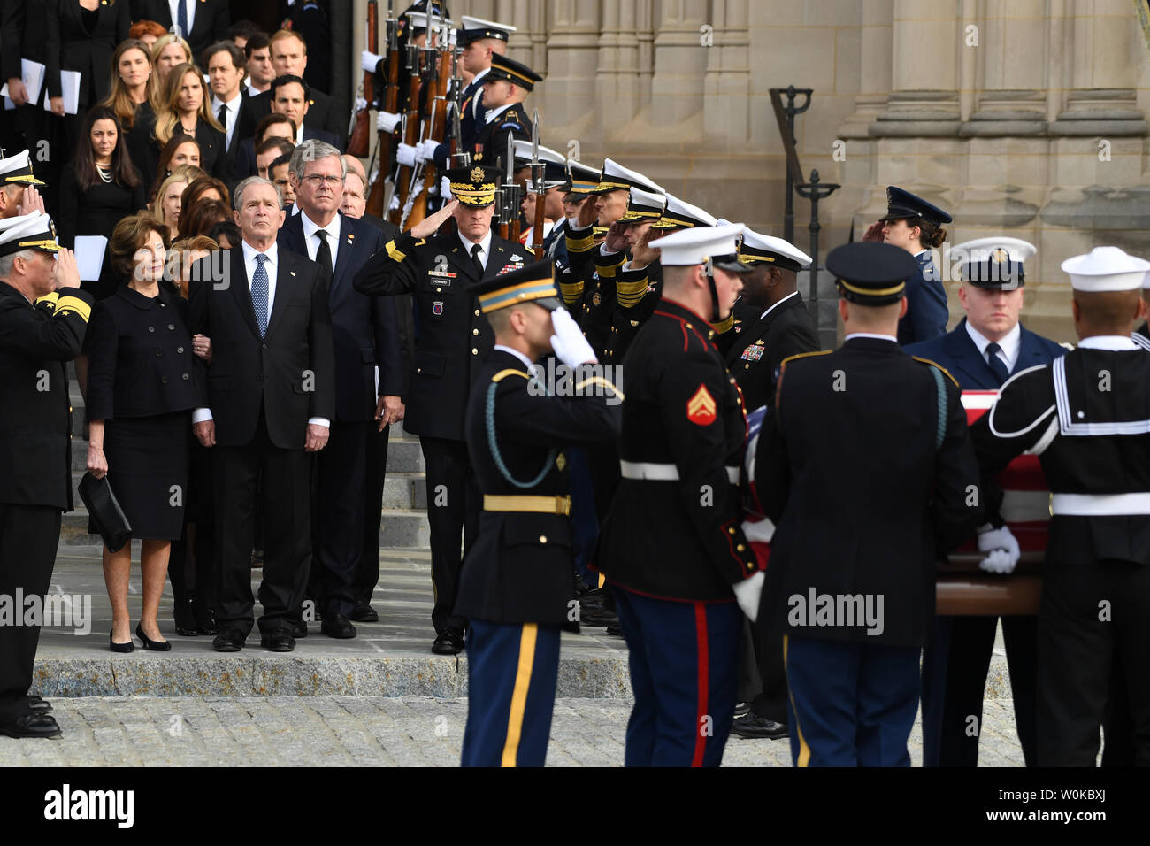 The casket of President George Herbert Walker Bush placed in the hearse as by sons George W. Bush and Jeb Bush watch following the funeral of the 41st President of the United States at the National Cathedral in Washington D.C. on December 5, 2018.   Photo by Pat Benic/UPI Stock Photo