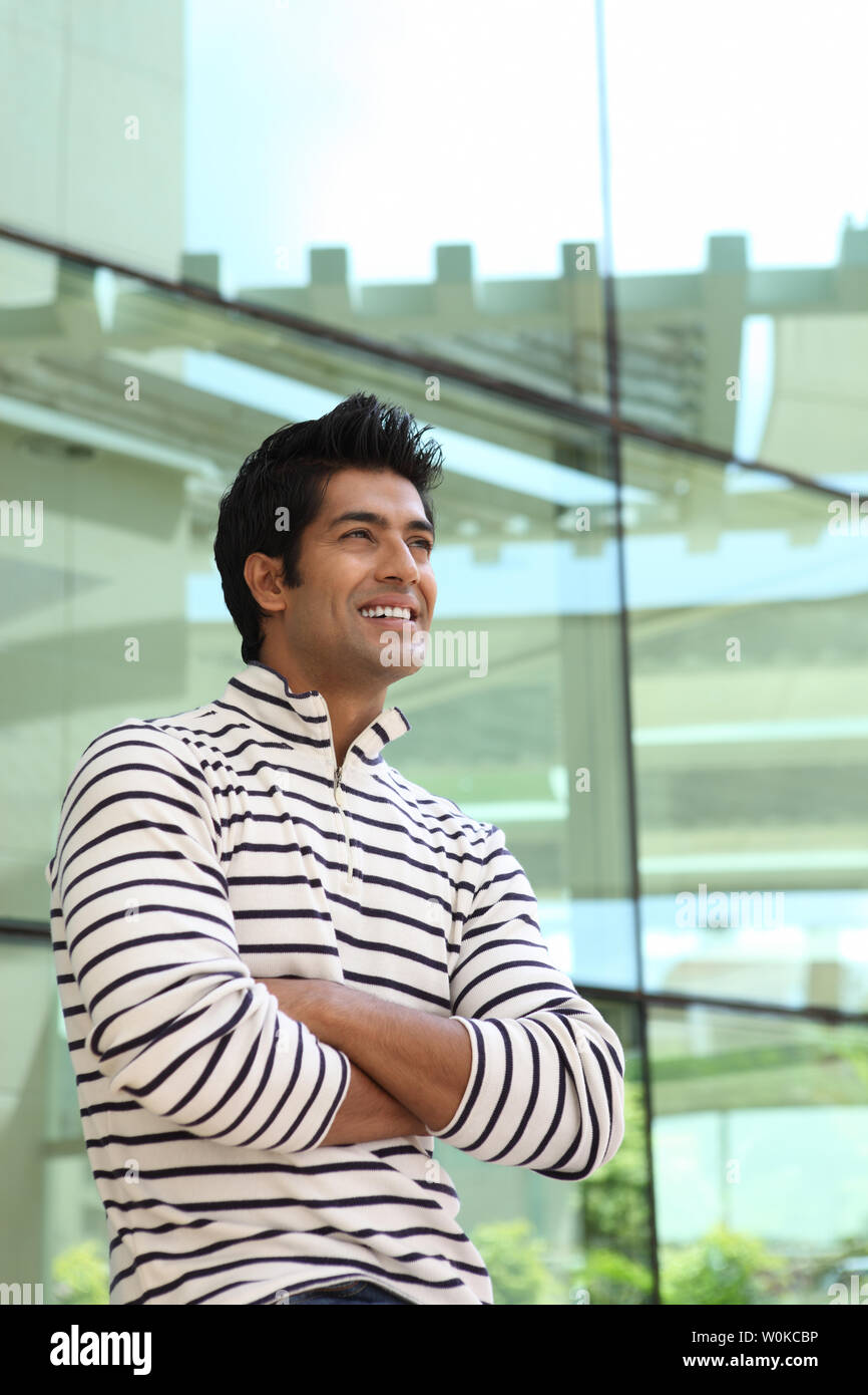 Indian young man smiling with his arms crossed Stock Photo - Alamy