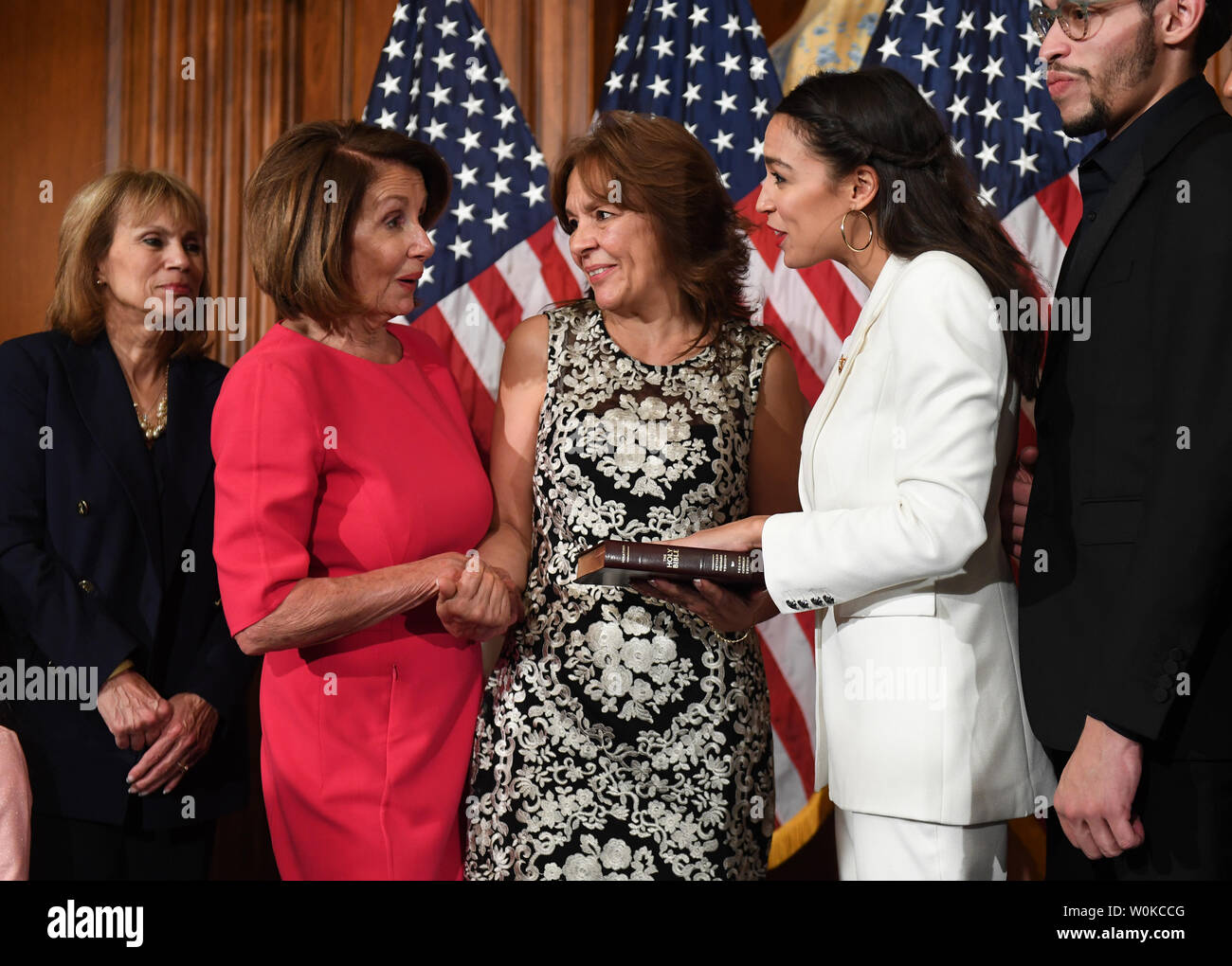 Newly elected Speaker of the House Nancy Pelosi talks with  Rep. Alexandria Ocasio-Cortez, D-NY, (in white) at a mock swearing-in event with family members at the U.S. Capitol in Washington, DC on January 3, 2019.  Pelosi became the first official to return to that position since Sam Rayburn in 1955.  Ocasio-Cortez is the youngest woman ever in Congress at age 29.     Photo by Pat Benic/UPI Stock Photo