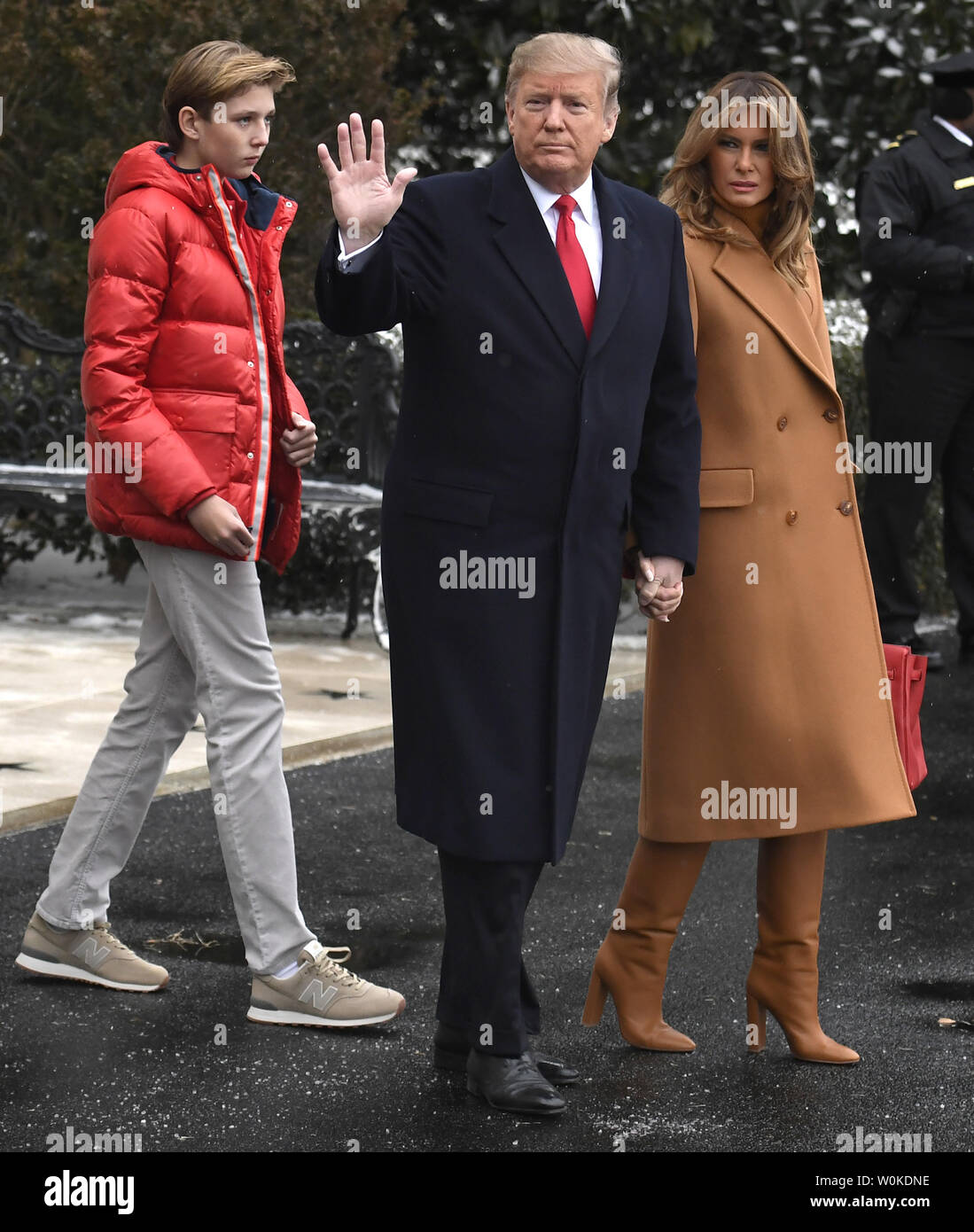 President Donald Trump, First Lady Melania Trump and son Barron pause as  they exit the White House, Washington, DC, on their way for a weekend trip  to Mar-a-Lago, Florida, Trump's first visit