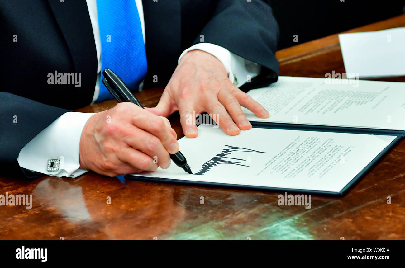 President Donald J. Trump signs the Space Policy Directive-4 (SPD-4), in the Oval Office at the White House in Washington, D.C. on February 19, 2019.  The directive instructs the Department of Defense to establish the the United States Space Force as the sixth branch of the Armed Forces. Trump was joined by members of his cabinet, Defense Department representatives and the National Space Council. Photo by Kevin Dietsch/UPI.. Stock Photo