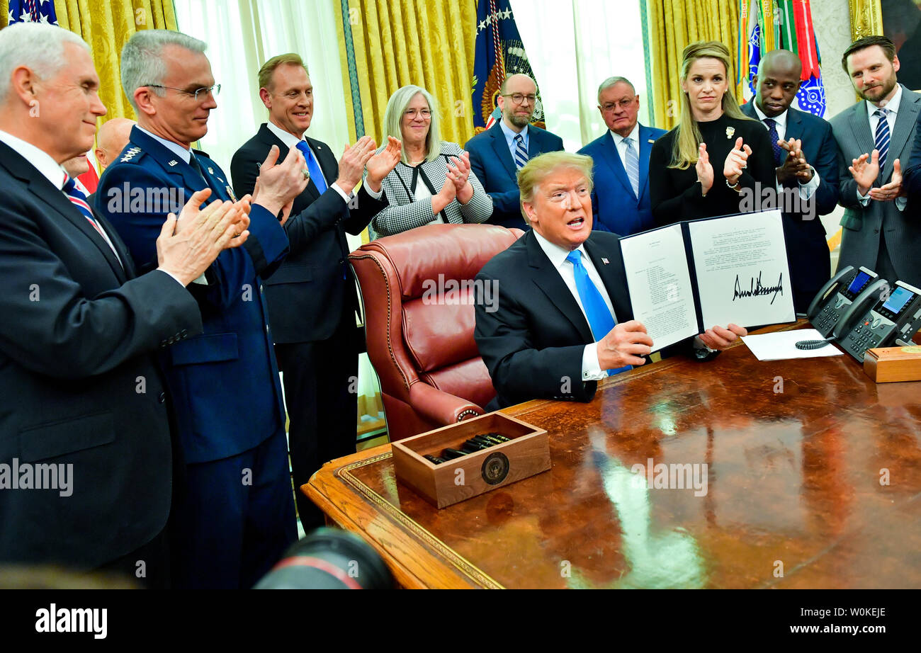 President Donald J. Trump signs the Space Policy Directive-4 (SPD-4), in the Oval Office at the White House in Washington, D.C. on February 19, 2019.  The directive instructs the Department of Defense to establish the the United States Space Force as the sixth branch of the Armed Forces. Trump was joined by members of his cabinet, Defense Department representatives and the National Space Council. Photo by Kevin Dietsch/UPI.. Stock Photo