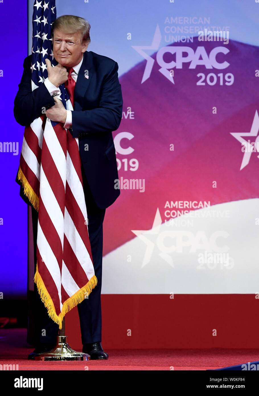President Donald Trump hugs the American flag as he arrives to address ...