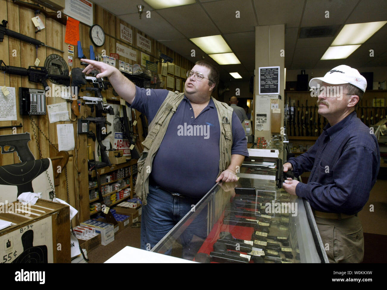 Salesman Tim Bacus (L) points out the Colt M4 carbin to a buyer at the