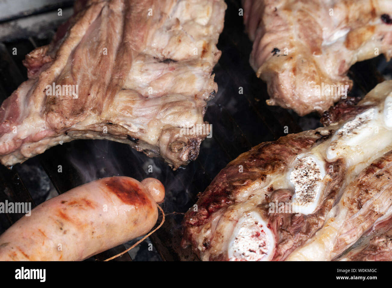Barbecue grill with grilled pork ribs, beef and criollo sausage. Spanish churrasco Stock Photo