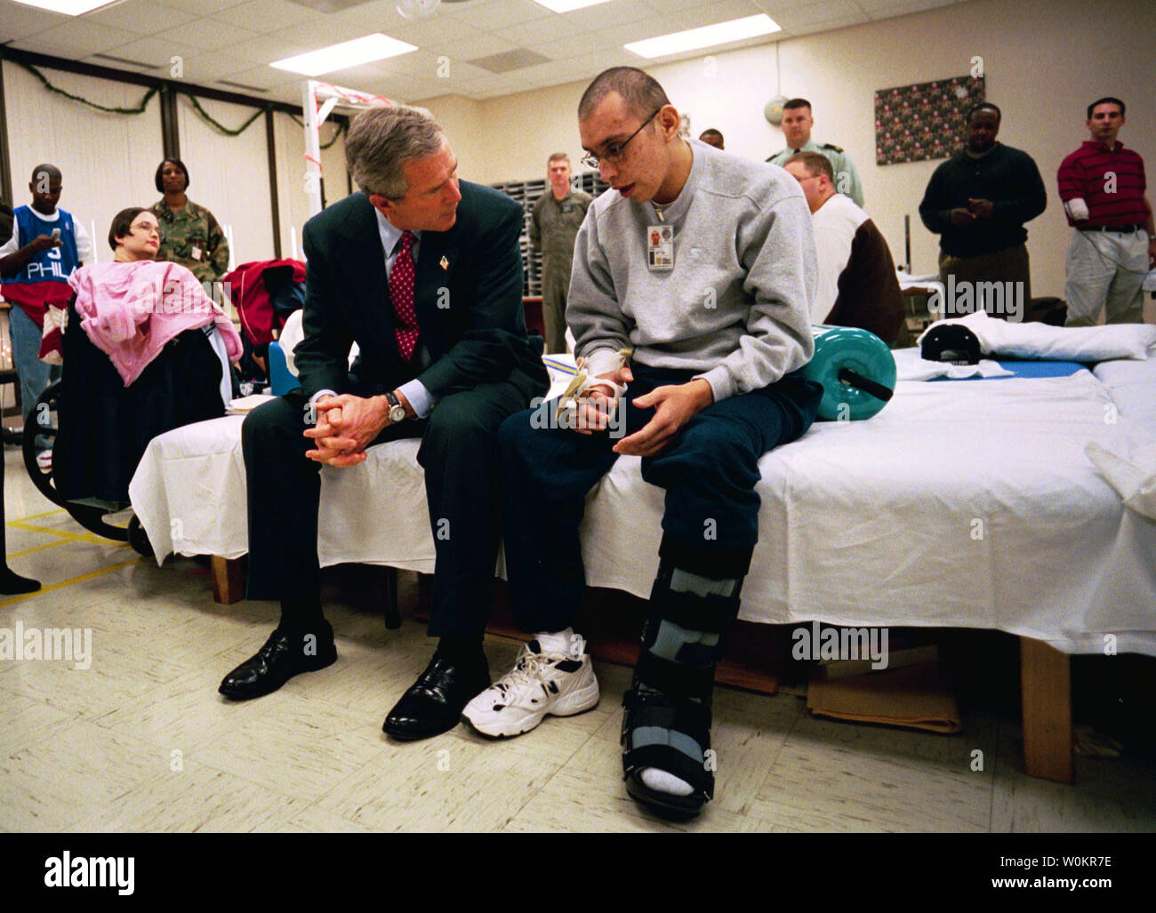 Visiting troops at Walter Reed Army Medical Center in Washington, D.C., President George W. Bush talks with U.S. Army Specialist Adolfo Lopez-Santini of San Diego, Calif., Thursday, Dec. 18, 2003. Spc. Lopez-Santini was injured while serving in Iraq. (UPI Photo/Eric Draper/White House) Stock Photo