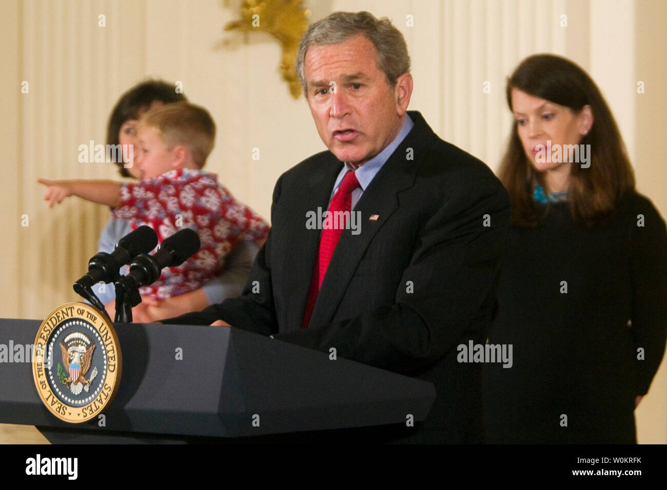 President George W. Bush , with Courtney Atnip, left, and son Carter, and Maura Daniel, right,  two of 21 families with children adopted as embryos, delivers a speech on bioethics in the East Room of the White House in Washington, May 24, 2005. The White House is criticizing pending legislation that would loosen restrictions on government funding of embryonic stem cell research as a vote in the U.S. House of Representatives draws near. (UPI Photo/Kamenko Pajic) Stock Photo