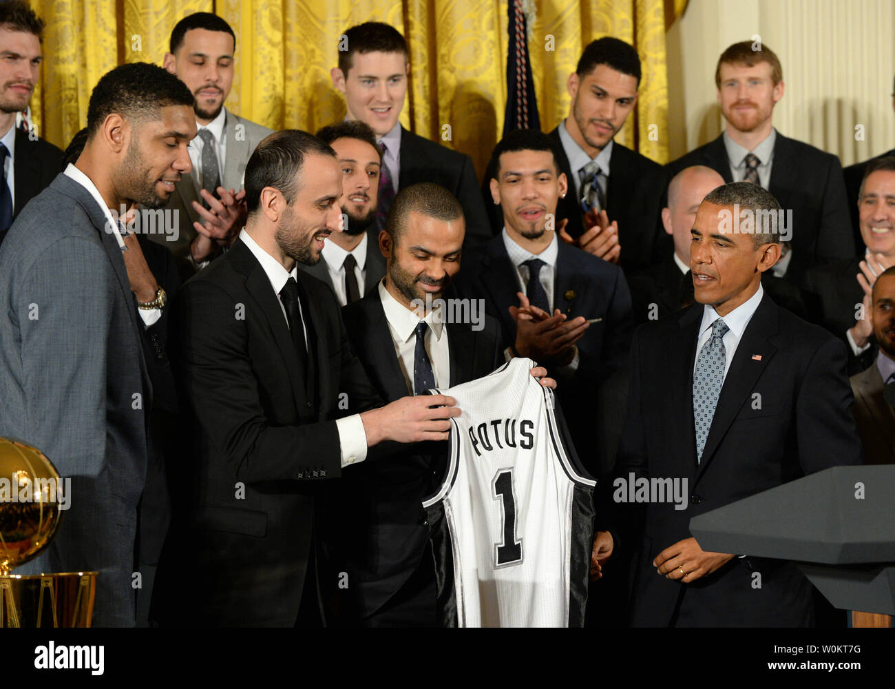 U.S. President Barack Obama receives a game jersey from San Antonio Spurs player Manu Ginobili (L) as Obama honors the 2014 NBA Champion Spurs in the East Room of the White House in Washington, DC. on January 12, 2015.  The Spurs won their fifth championship.   Photo by Pat Benic/UPI Stock Photo