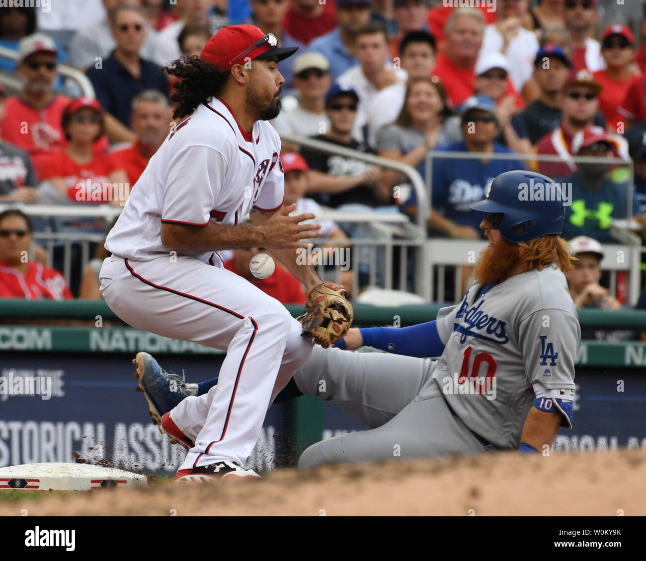 Washington Nationals center fielder Trea Turner (R) slides safely into  third base as Los Angeles Dodgers third baseman Justin Turner bobbles the  throw during the third inning in game 5 of the