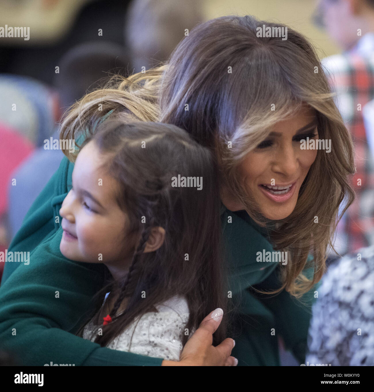 First Lady Melania Trump hugs a child as they write holiday cards for the Marine Corps Reserve Toys for Tots Campaign at Joint Base Anacostia-Bolling in Washington, DC on December 13, 2017.  The first lady helped sort and box toys at the base with military children to help other children in the DC area.   Photo by Pat Benic/UPI Stock Photo