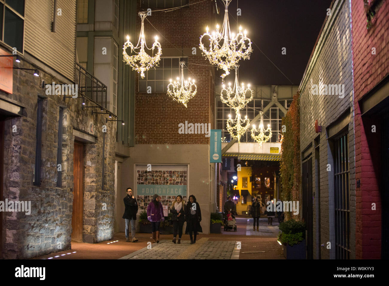 People walk under 'Open Lounge' an installation of chandelier over Cady's Alley in Georgetown which is part of Georgetown GLOW in Washington, DC on December 9, 2017. GLOW is an annual outdoor public light exhibit put together by the Georgetown Business Improvement District.     Photo by Erin Schaff/UPI Stock Photo