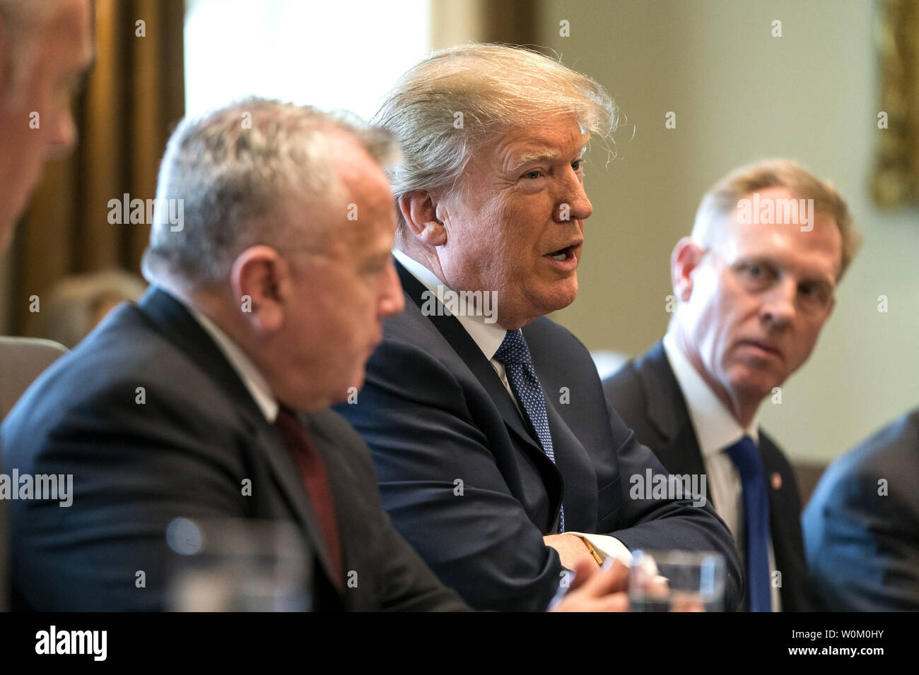 President Donald J. Trump (C) speaks with the media before a meeting with his cabinet in the Cabinet Room of the White House in Washington DC on April 9, 2018. Trump said he will decide in the next few days whether  the US will respond militarily for the reported chemical weapons attack in Syria.  Photo by Jim Lo Scalzo/UPI Stock Photo