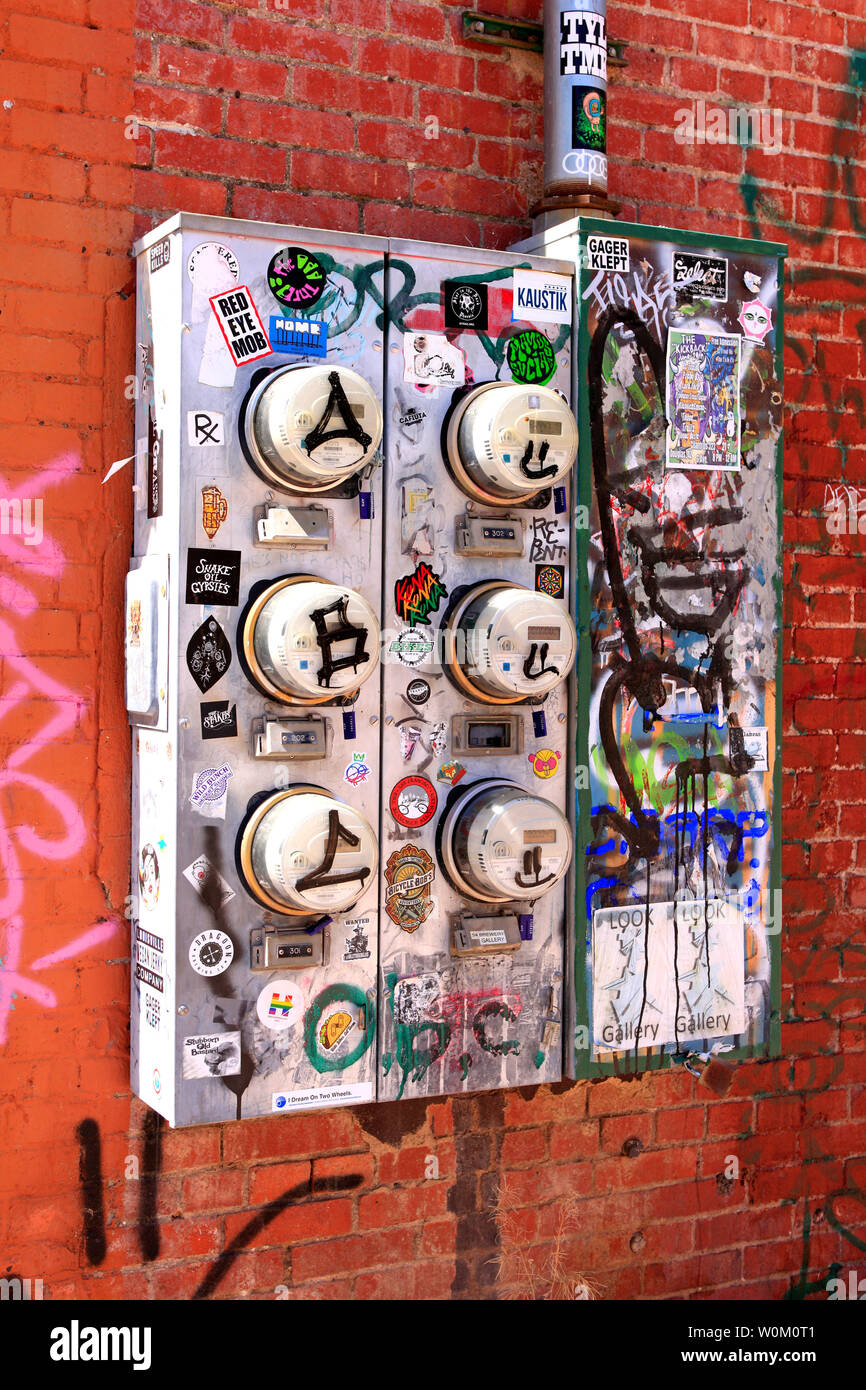 Multiple electric meter boxes covered in graffiti and stickers Stock Photo