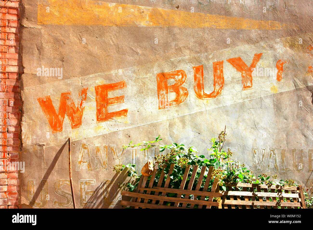 Old paintwork painted on a wall saying 'We Buy' in downtown Bisbee, AZ Stock Photo
