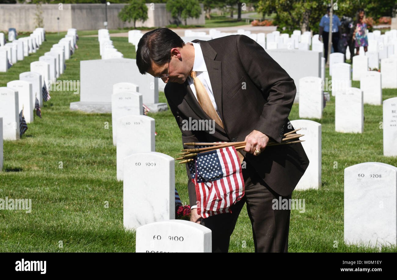 Secretary of the Army Dr. Mark T. Esper places a flags in front of