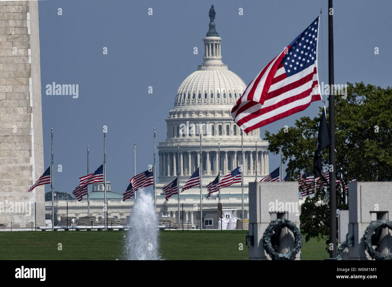 With the U.S. Capitol in the background the flags at the Washington Monument and World War II Memorial fly at half-staff in honor of Senator John McCain, in Washington on August 28, 2018. After pressure from congress and the public, President Donald Trump reversed his decision and ordered the flags at the White House and elsewhere to fly at half-staff until McCain is buried.    Photo by Pat Benic/UPI Stock Photo