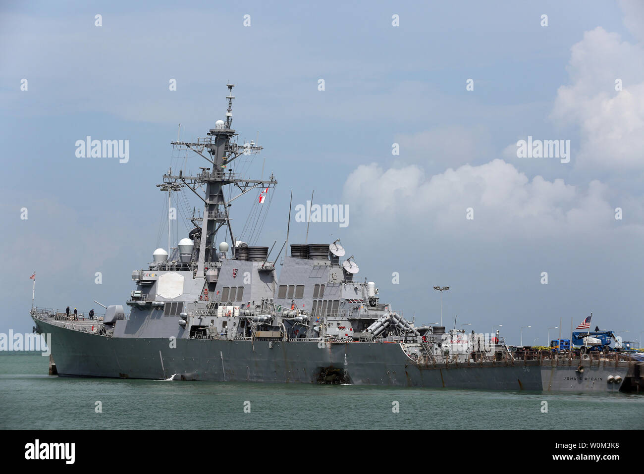 Guided-missile destroyer USS John S. McCain (DDG 56) moored pier side at Changi Naval Base, Republic of Singapore, on August 21, 2017, following a collision with the merchant vessel Alnic MC while underway east of the Straits of Malacca and Singapore earlier that day. Significant damage to the hull resulted in flooding to nearby compartments, including crew berthing, machinery, and communications rooms. Damage control efforts by the crew halted further flooding. The incident will be investigated. Photo by Grady T. Fontana/U.S. Navy/UPI Stock Photo