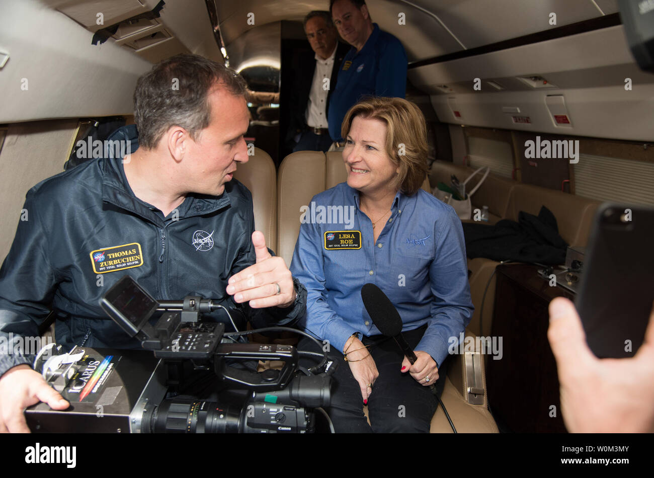 NASA Associate Administrator for the Science Mission Directorate Thomas Zurbuchen explains to acting NASA Administrator Lesa Roe how the spectrograph showing different colors correlate to different elements, such as helium, in the Sun's atmosphere during the solar eclipse on August 21, 2017, from onboard a NASA Armstrong Flight Research CenterÕs Gulfstream III 35,000 feet above the Oregon Coast. A total solar eclipse swept across a narrow portion of the contiguous United States from Lincoln Beach, Oregon to Charleston, South Carolina. NASA Photo by Carla Thomas/UPI Stock Photo