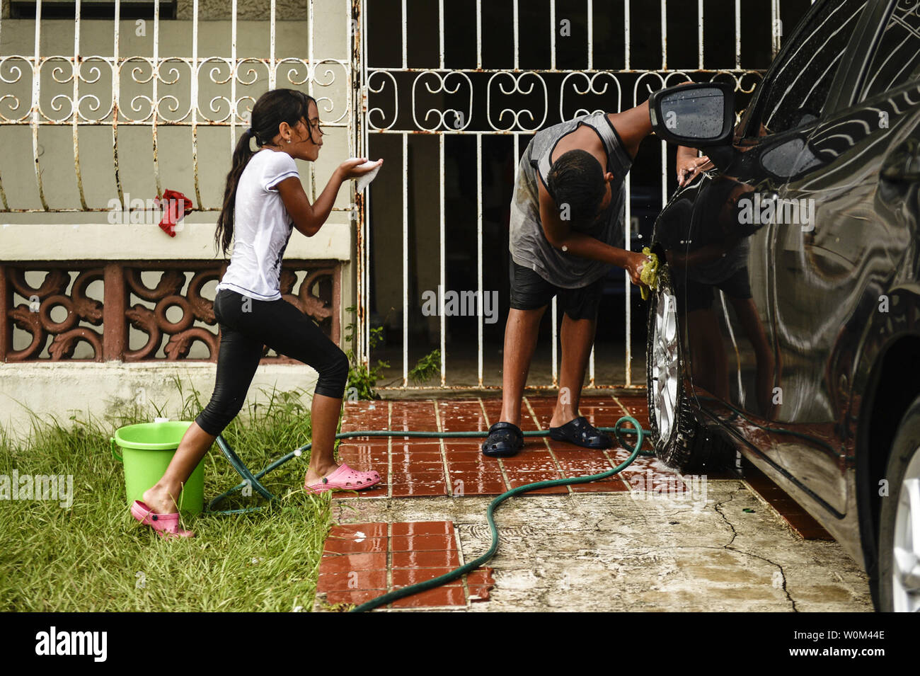 Fabiola Vazquez Barriel, 10, helps her brother, Junian, 14, wash their father's car in San Juan, Puerto Rico, on October 3, 2017. The people of Puerto Rico are resilient, evidenced by the stories of neighbor helping neighbor, and communities helping communities after Hurricane Maria devastated the island. Photo by Master Sgt. Joshua DeMotts/U.S. Air Force/UPI Stock Photo