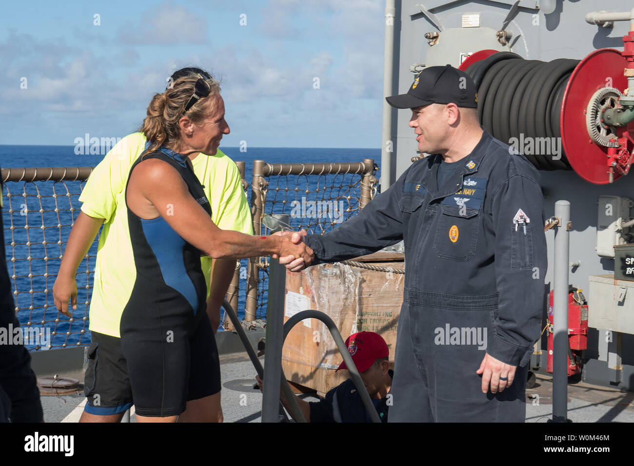 USS Ashland (LSD 48) Command Master Chief Gary Wise welcomes aboard Jennifer Appel, an American mariner who had received assistance from Ashland crew members, on October 25, 2017. Ashland, operating in the Indo-Asia-Pacific region on a routine deployment, rescued two American mariners who had been in distress for several months after their sailboat had a motor failure and had strayed well off its original course while traversing the Pacific Ocean. Photo by MC3 Jonathan Clay/U.S. Navy/UPI. Stock Photo