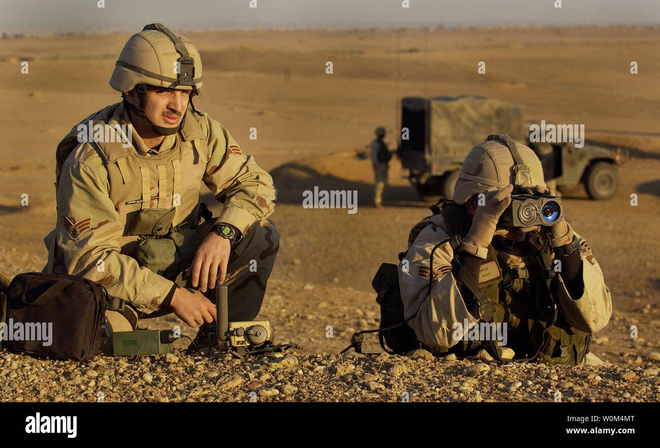 Senior Airman Leo Ortiz and Senior Airman Josh Gianni, Tactical Air Control Party, 4th Air Support Group, eye a strategic target on the horizon in Kirkuk, Iraq, as part of Operation Ivy Cyclone, a combined-arms operation designed to root out and crush insurgents in Iraq recently.  Picture release November 24, 2003. (UPI Photo/Jeffrey A. Wolfe/Air Force) Stock Photo