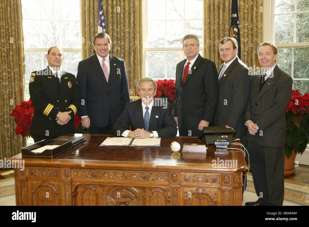 President George W. Bush poses Tuesday December 16, 2003 in the Oval Office with from left to right: Chuck Canterbury, National President, Fraternal Order of Police; Secretary of Homeland Security Tom Ridge; Harold Schaitberger, General President of the International Association of Fire Fighters; Kevin O’Connor, Assistant to the General President of the International Association of Fire Fighters for Government and Public Affairs; and James Pasco, Executive Director of the National Fraternal Order of Police. The photo opportunity was in recognition of  the Hometown Heroes Survivors Benefits Act Stock Photo