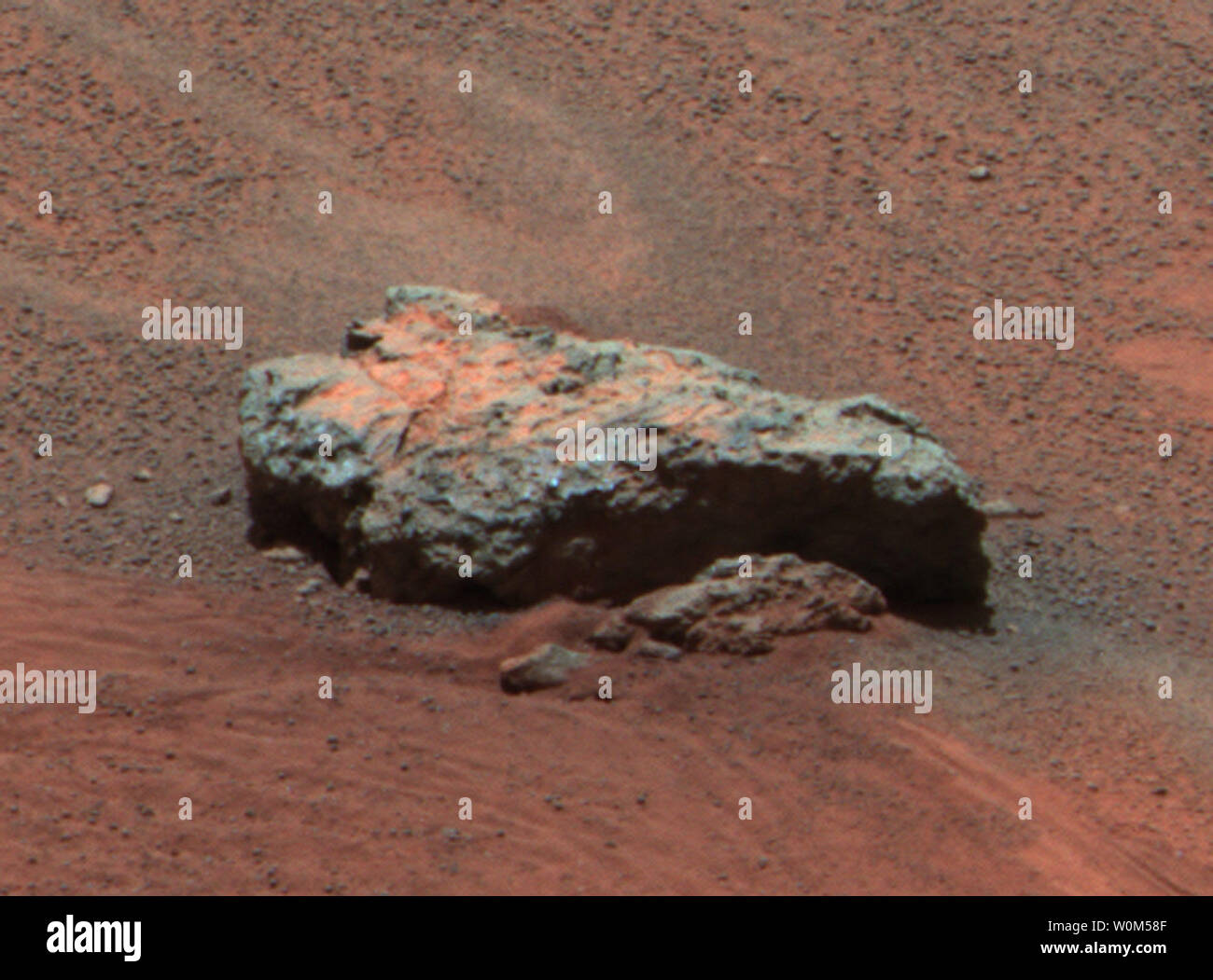 This Mars Exploration Rover Opportunity panoramic camera image shows 'Bounce Rock,' a rock the airbag-packaged rover struck while rolling to a stop on January 24, 2004. This is the largest rock for as far as the eye can see, approximately 35 centimeters (14 inches) long and 10 centimeters (4 inches) high. There appears to be a dusty coating on the top of parts of the rock, which may have been broken when it was struck by the airbags. The rock was about 5 meters (16 feet) from the rover when this image was obtained. This is an enhanced color composite image from sol 36 of the rover's journey, g Stock Photo