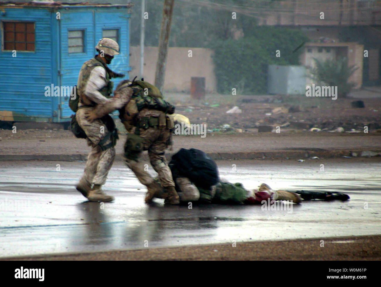 Gunnery Sgt. Ryan P. Shane (C), Company B, 1st Battalion 8th Marine Regiment, Regimental Combat Team 7, pulls a fatally wounded Marine from the battle in Fallujah, Iraq on November 5, 2004. Seconds later Shane was also wounded by enemy fire.  Photo released December 21.  (UPI Photo/Joel Chaverri/U.S. Marines) Stock Photo