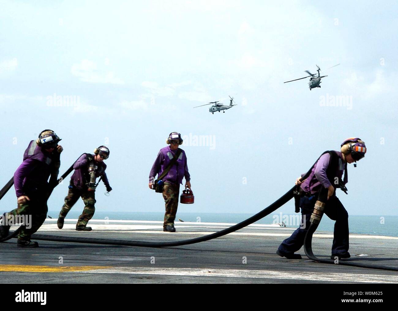 Helicopters depart after being re-fueled aboard the USS Abraham Lincoln on December 31, 2004 in the Indian Ocean.  The Seahawk helicopters are en route to Aceh, Sumatra, Indonesia. The helicopters are transporting supplies, bringing in disaster relief teams and supporting humanitarian airlifts to Tsunami-stricken coastal regions.  (UPI Photo/Seth C. Peterson via Navy) Stock Photo