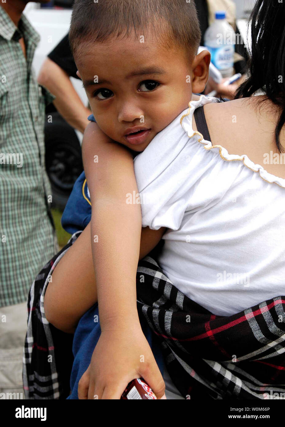 An Indonesian boy with his mother awaits medical attention after being evacuated from a coastal village to at Sultan Iskandar Muda Air Force Base in Banda Aceh, Indonesia on January 5, 2005   (UPI Photo/Jordon R. Beesley/USN) Stock Photo