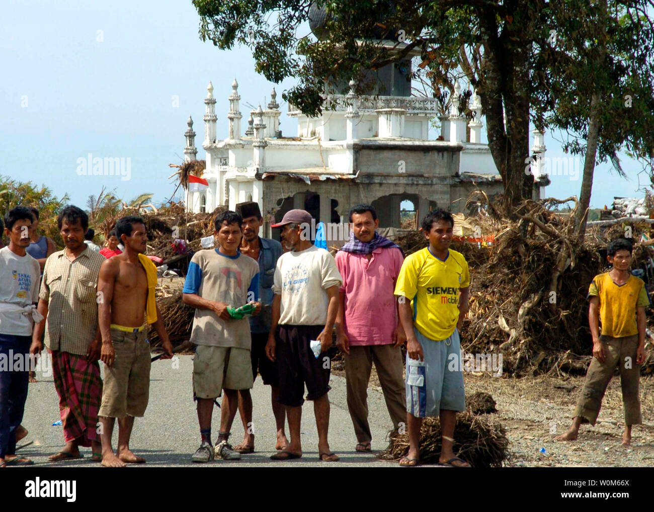 Indonesian citizens gather outside a mosque flying the red and white
