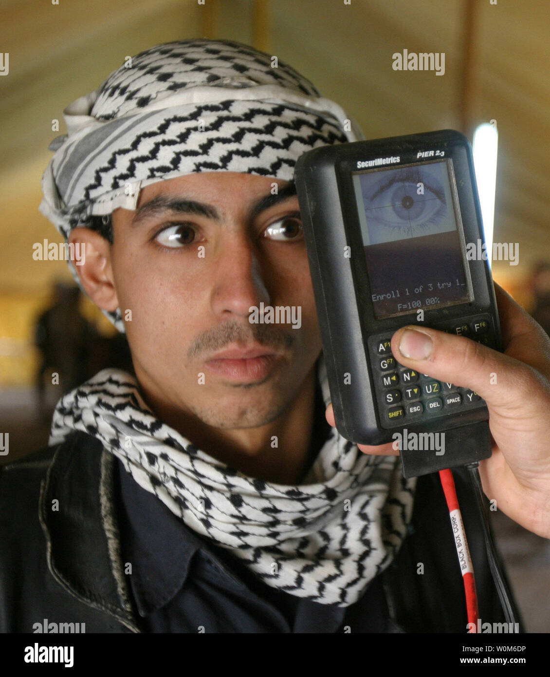 Marine Lance Cpl. Luis Molina scans an Iraqi citizen's retina at Brahma Park in Fallujah, Iraq, on Jan 25, 2005.  U.S. Marines are utilizing a Biometric Analysis Tracking System to record and identify Iraqi civilians entering the battle torn city of Fallujah in an attempt to find and identify insurgent forces.  The tracking system uses thumbprints, a photograph of the face, and a retinal scan to establish positive identity.  (UPI Photo/Jonathan C. Knauth/Marines) Stock Photo