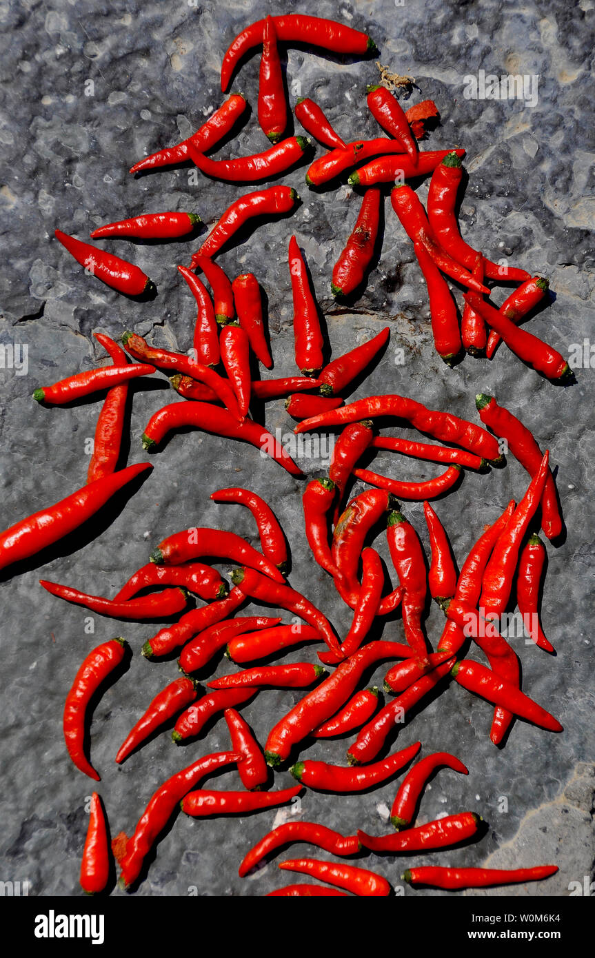 Red chilli peppers drying on a stone wall, Guilin, China Stock Photo ...