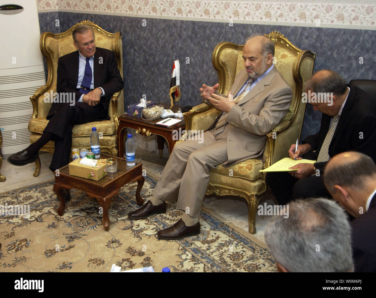 Secretary of Defense Donald H. Rumsfeld  ( left) listens to Iraqi Prime Minister Ibrahim Jafari (center) during a meeting in his residence in Baghdad, Iraq, on April 12, 2005.   Rumsfeld is in Iraq to visit with U.S. and coalition forces and to meet with the newly elected members of the Iraqi government.   (UPI Photo/ Cherie A. Thurlby/Air Force) Stock Photo