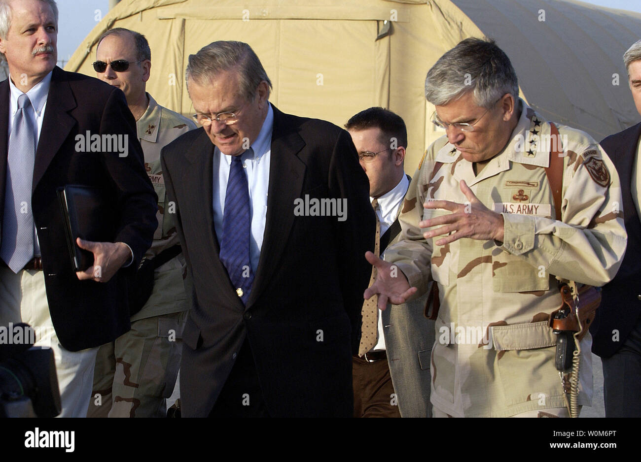 Commander of the Multi-National Forces-Iraq Gen. George Casey, U.S. Army, talks with Secretary of Defense Donald H. Rumsfeld as they walk through Camp Sather at Baghdad International Airport in Iraq on April 12, 2005.  Rumsfeld met earlier with senior leaders from the Multi-National Forces-Iraq and Multi-National Corps-Iraq. Rumsfeld is in Iraq to visit with U.S. and coalition forces and to meet with the newly elected members of the Iraqi government.   (UPI Photo/ Cherie A. Thurlby/Air Force) Stock Photo