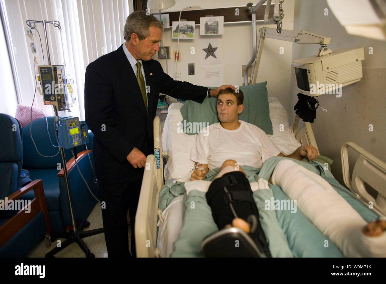 President George W. Bush spends a moment with Cpl. Cole Hansen of Canby, Minn., during a visit to Walter Reed Army Medical Center Friday, July 1, 2005.Ê Cpl. Hansen is recovering from wounds received while serving in Iraq.Ê    (UPI Photo/Eric Draper/White House) Stock Photo
