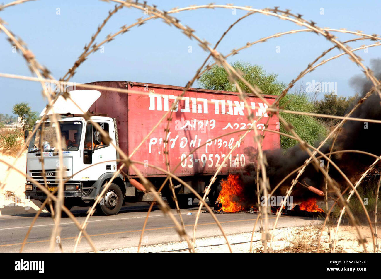 A moving van works around road blocks near the Nezer Hazani settlement as Israeli Defense Force personel arrive to serve eviction notices in Gush Katif, Gaza, on Aug. 15, 2005. Residents resisted as Israel began the Gaza pullout, posting 48 hour eviction notices to about 9,000 settlers in 21 Gaza camps.   (UPI Photo/IDF) Stock Photo