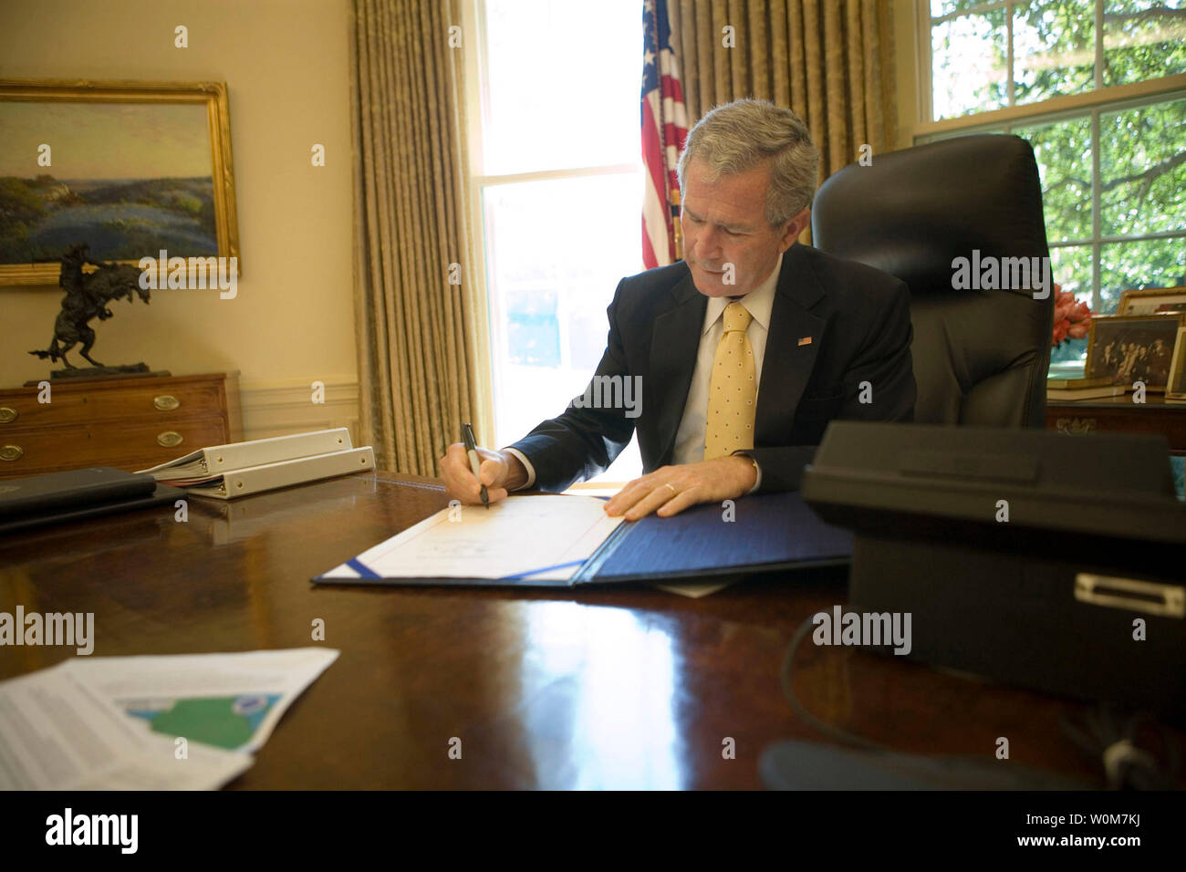 President George W. Bush signs into law H.R. 3169, the 'Pell Grant Hurricane and Disaster Relief Act,' which authorizes the Department of Education to waive requirements for Pell Grant repayments if student withdrawals from institutions of higher education are due to major disasters, on Sept. 21, 2005, in the Oval Office. The President also signed into law two other hurricane-related bills: H.R. 3668, the 'Student Grant Hurricane and Disaster Relief Act,' and H.R. 3672, the 'TANF Emergency Response and Recovery Act of 2005.'   (UPI Photo/Eric Draper/White House) Stock Photo