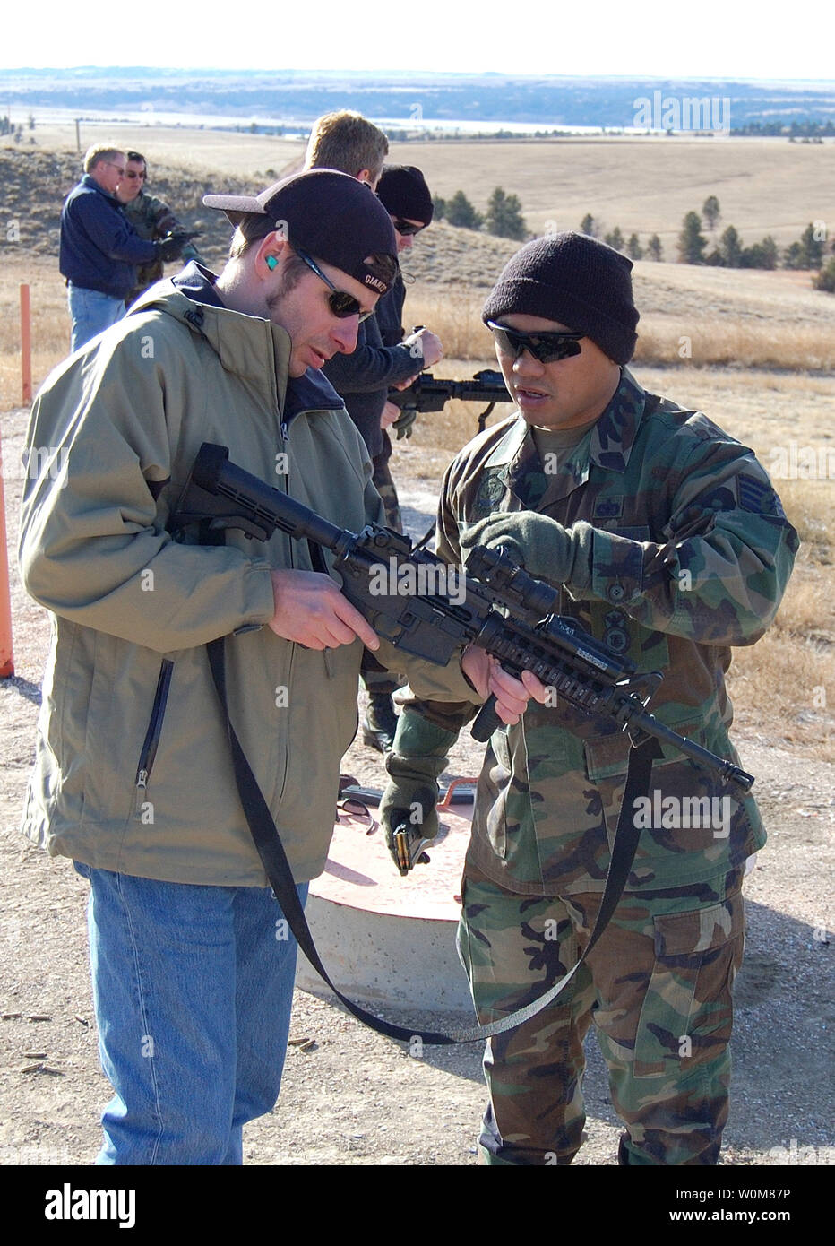 3D-Artist John Nascone is shown how to operate a M-16 rifle by Sgt. Purdy, at Green Up training at Camp Guernsey, Wyoming on January 24 2006. The event provided real world and hands on combat and weapons training to the development team of the America's Army video game, a title used for information and recruiting by the United States Army. (UPI Photo/Chris Barylick) Stock Photo