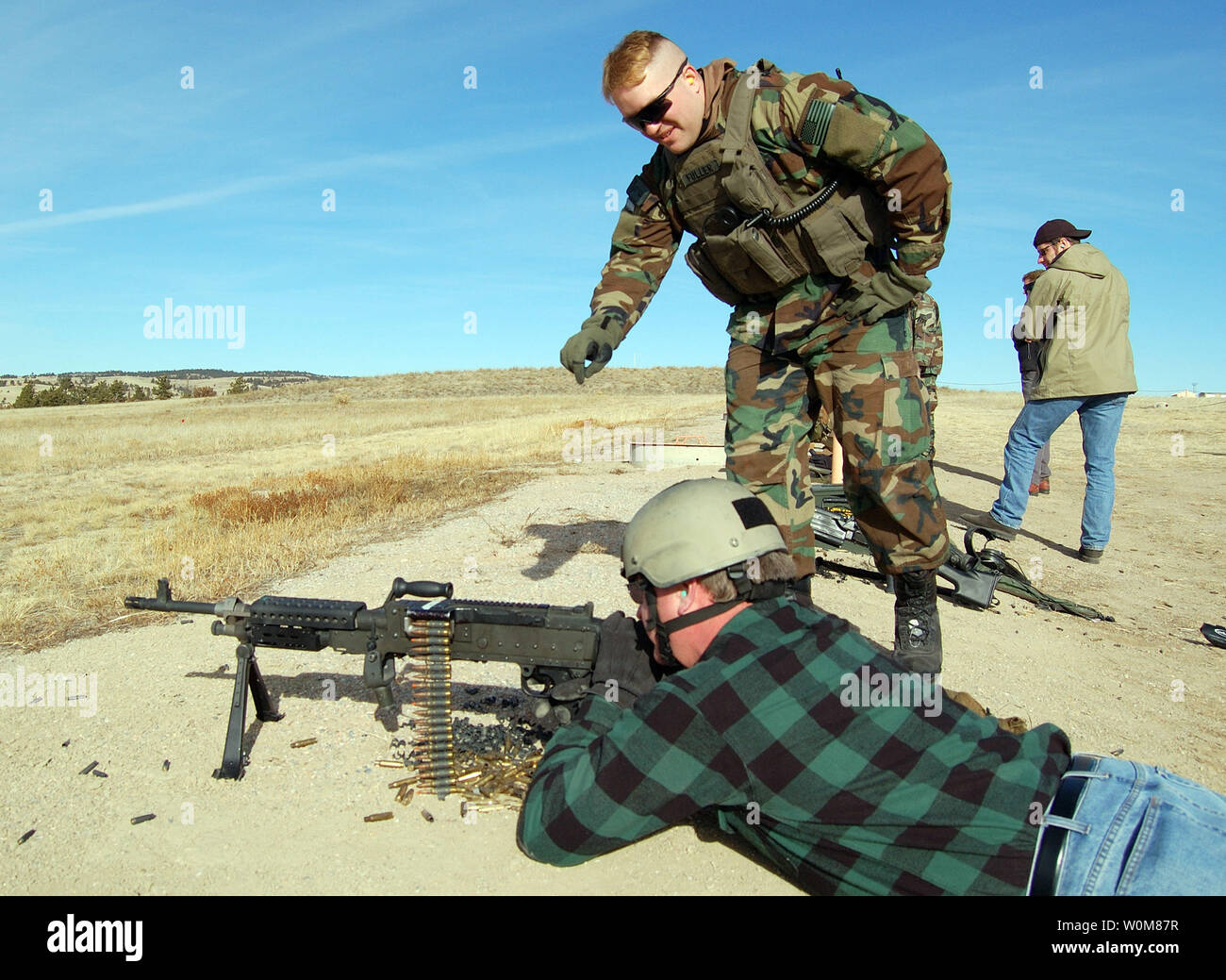 An American Army coordinator Kelly McGuire is shown how to operate an M-60 machine gun by Sgt. Burnell, at Green Up training at Camp Guernsey, Wyoming on January 24 2006. The event provided real world and hands on combat and weapons training to the development team of the America's Army video game, a title used for information and recruiting by the United States Army. (UPI Photo/Chris Barylick) Stock Photo
