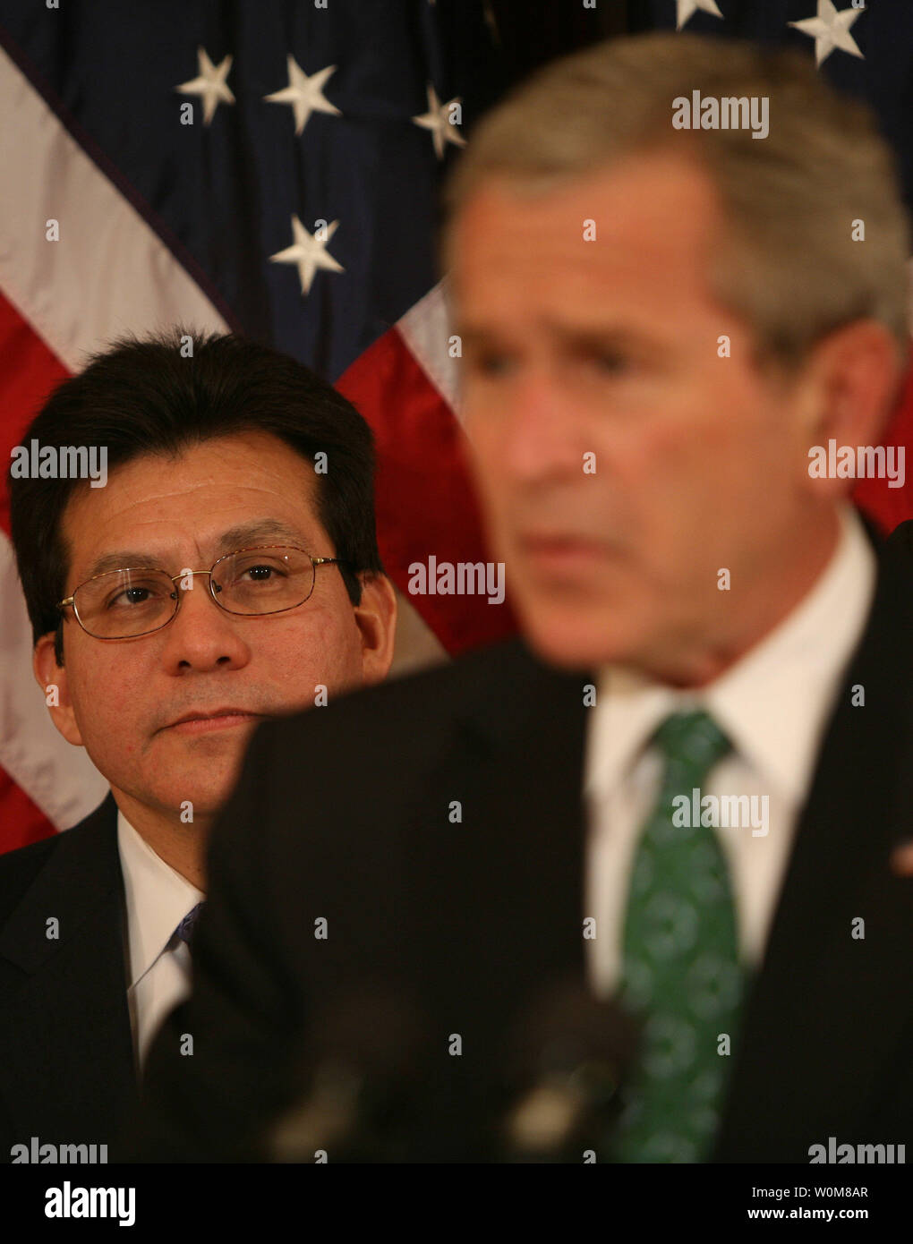 Attorney General Alberto Gonzales watches President George W. Bush speak before the signing of H.R. 32, the Stop Counterfeiting in Manufactured Goods Act in the Eisenhower Executive Office Building on March 16, 2006.  Agency pool  by Dennis Brack, Black Star Stock Photo