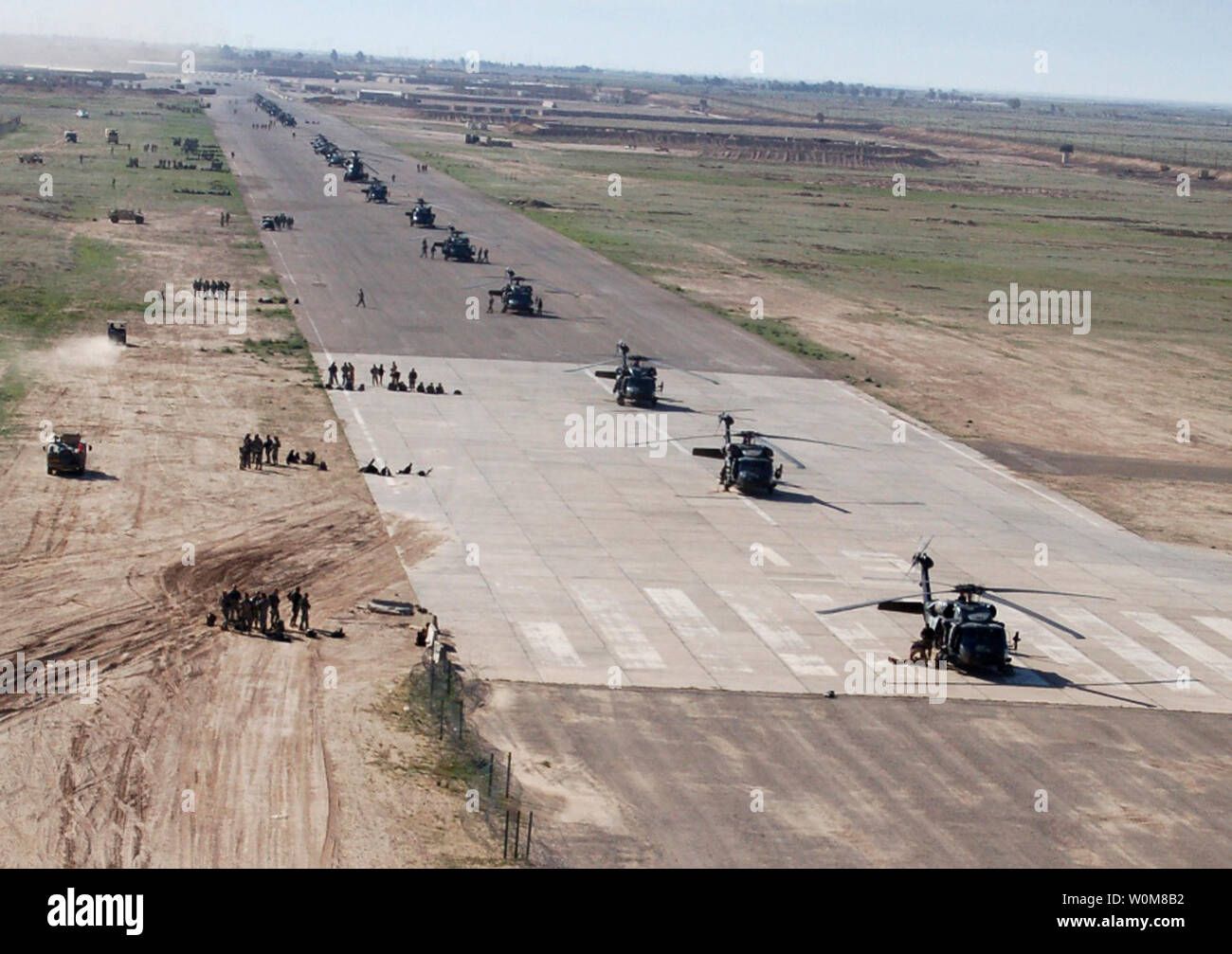 U.S. Army soldiers, Iraqi soldiers and U.S. aircraft are positioned on the airstrip at Forward Operating Base Remagen, Iraq, in preparation for Operation Swarmer on March 16, 2006.  Operation Swarmer is a combined air assault operation to clear the area northeast of Samarra of suspected insurgents.  The soldiers are from the Iraqi Army's 1st Brigade, 4th Division, and the U.S. Army's 101st Airborne Division's 3rd Brigade Combat Team, and the 101st Combat Aviation Brigade.  (UPI Photo/Antony Joseph/U.S. Army) Stock Photo