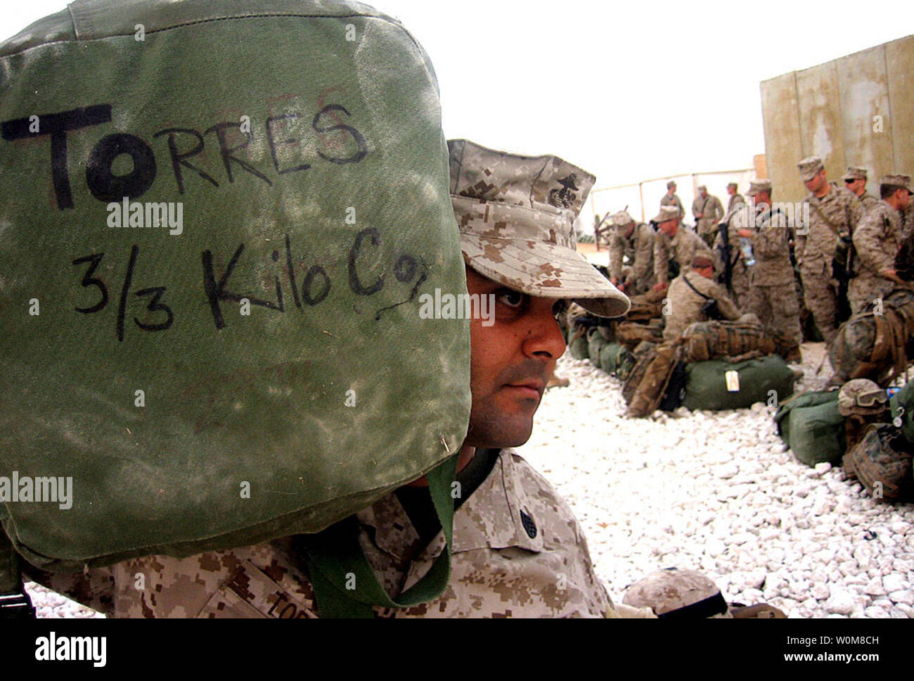 Staff Sgt. Ronnie Torres, a 29-year-old platoon sergeant from Kilo Company, 3rd Battalion, 3rd Marine Regiment, based out of Kaneohe Bay, Hawaii, carries his sea bag to his tent after arriving to an airbase at Al Asad, Iraq, March 17, 2006. Just eight months after their deployment to Afghanistan, the Hawaii-based Marines have departed their base in Hawaii for a seven-month deployment in support of Operation Iraqi Freedom.  (UPI Photo/Sgt. Roe F. Seigle/USMC) Stock Photo