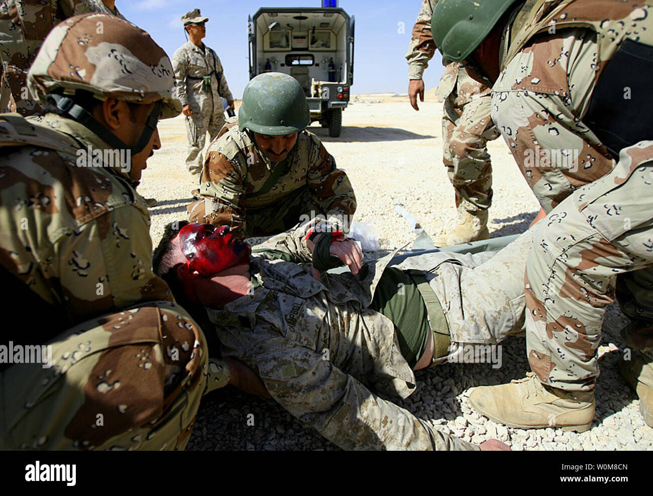Iraqi soldiers lift Hospitalman James J. Campbell, a U.S. Navy corpsman with Regimental Combat Team 7 and mock casualty role-player, onto a stretcher before loading him into an ambulance during a mass casualty drill March 19, 2006, at the Iraqi Army camp at Al Asad, Iraq. The Iraqi soldiers, part of the 2nd Brigade, 7th Iraqi Army Division, conducted the drill to practice their response in the event of a real mass casualty event.   (UPI Photo/Staff Sgt. Jim Goodwin/USMC) Stock Photo