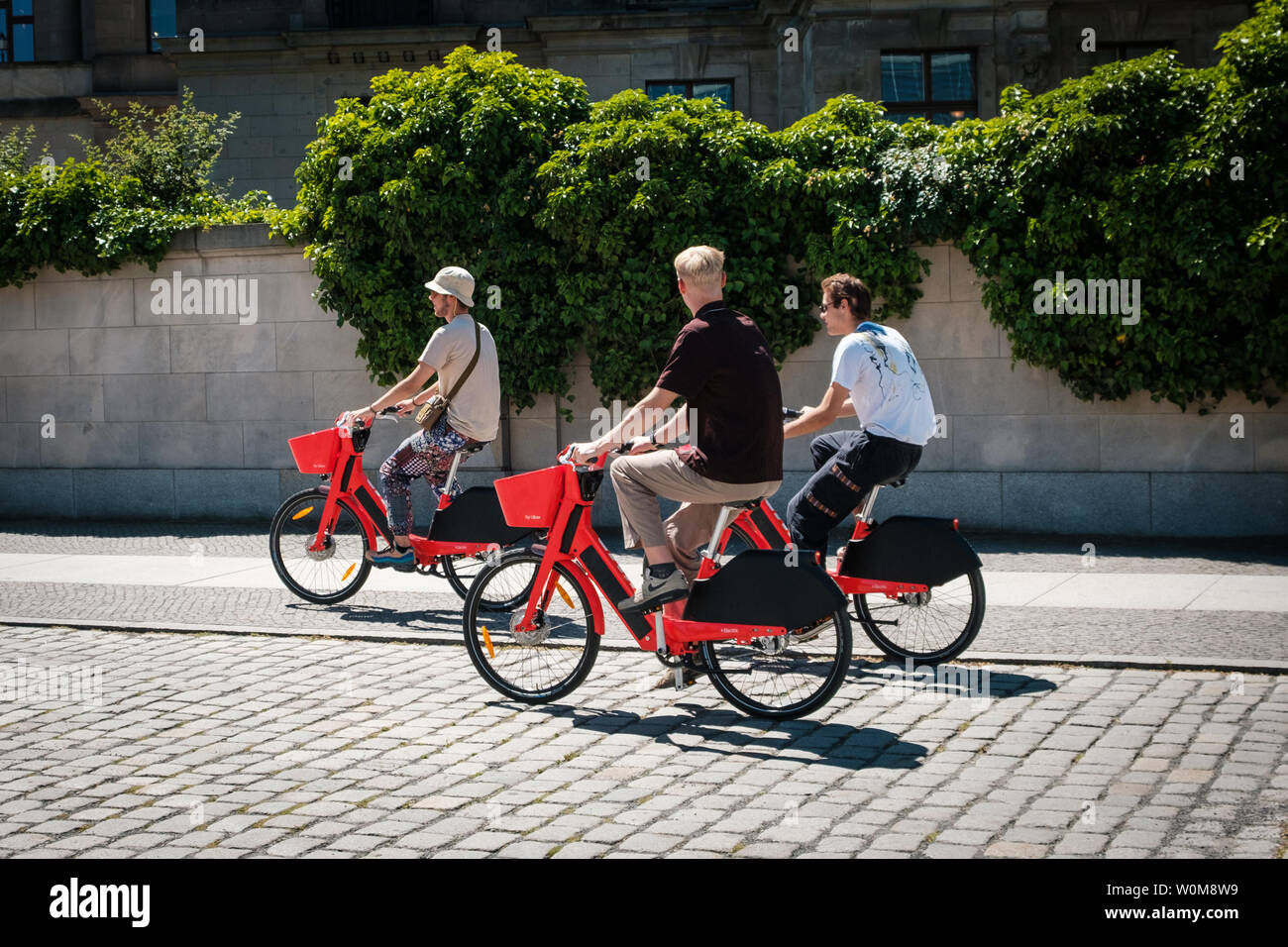 Berlin, Germany - June, 2019: Three young men riding ebikes or. electric bikes of   bicycle sharing service  JUMP by UBER  in Berlin Stock Photo