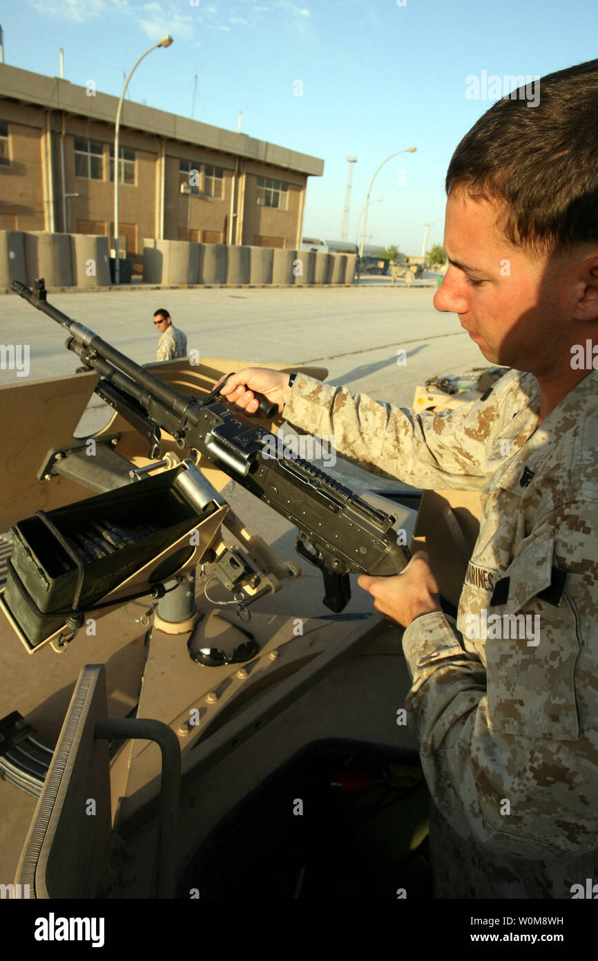Cpl. Michael T. Wier, from 1st Battalion, 7th Marine Regiment, or “First Team,” provides weapons maintenance to his vehicle’s main gun before “leaving the wire” for a mission on Al Anbar Province’s dangerous roads, June 3, 2006. The 22-year-old from Scottsdale, Ariz., is with the battalion’s Personal Security Team. The team’s job is cut and dry – provide maximum security for the battalion’s top brass. The team consists of a handful of armored humvees with a variety of infantry weapons, to include heavy machine guns and anti-armor weapons. While most U.S. Marine Personal Security Teams are comp Stock Photo