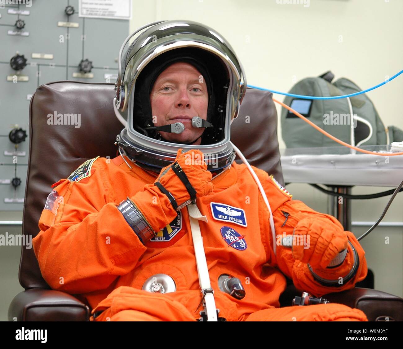 The STS-121 crew are donning their orange launch and entry suits for launch today on Space Shuttle Discovery on July 1, 2006. Adjusting his helmet is Mission Specialist Michael Fossum, who is making his first space flight. The launch is the 115th shuttle flight and the 18th U.S. flight to the International Space Station. During the 12-day mission, the STS-121 crew will test new equipment and procedures to improve shuttle safety, as well as deliver supplies and make repairs to the International Space Station. (UPI Photo/Kim Shiflett/NASA) Stock Photo