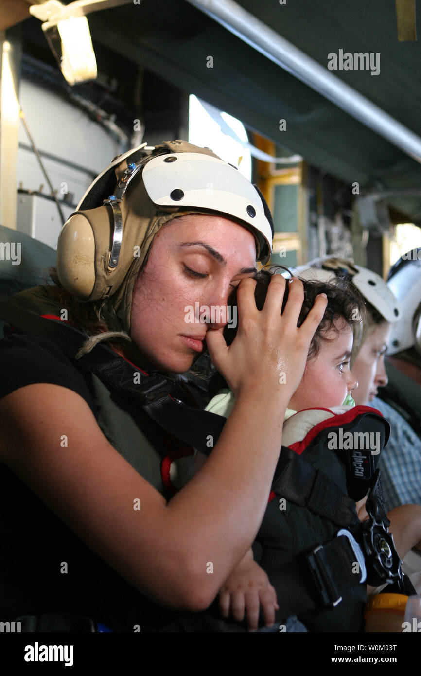 An American woman calms a child while flying in a U.S. Marine Corps CH-53 Super Stallion helicopter from the U.S. Embassy in Beirut, Lebanon, to Royal Air Force Base Akrotiri in Cyprus on July 18, 2006. At the request of the U.S. Ambassador to Lebanon and at the direction of the Secretary of Defense, the United States Central Command and 24th Marine Expeditionary Unit are assisting with the departure of U.S. citizens from Lebanon. The helicopters are attached to Marine Medium Helicopter Squadron 365. (UPI Photo/James H. Frank/U.S. Marine Corps) Stock Photo