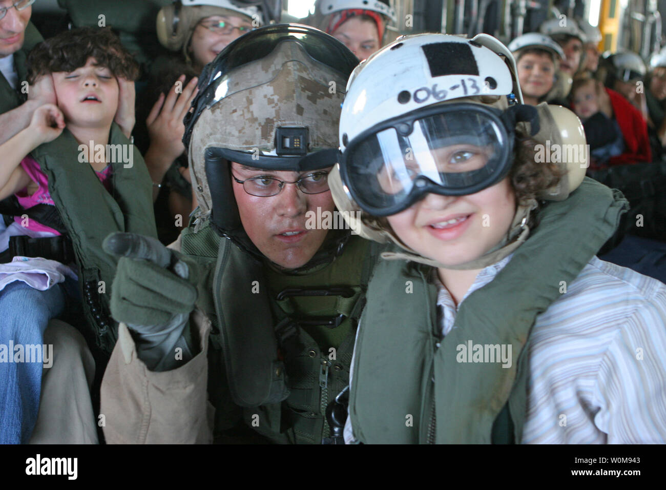 A Marine aircrewman helps a child look out the open door of a U.S. Marine Corps CH-53 Super Stallion helicopter while flying from the U.S. Embassy in Beirut, Lebanon, to Royal Air Force Base Akrotiri in Cyprus on July 18, 2006. At the request of the U.S. Ambassador to Lebanon and at the direction of the Secretary of Defense, the United States Central Command and 24th Marine Expeditionary Unit are assisting with the departure of U.S. citizens from Lebanon.  The helicopters are attached to Marine Medium Helicopter Squadron 365. (UPI Photo?James H. Frank/U.S. Marine Corps) Stock Photo